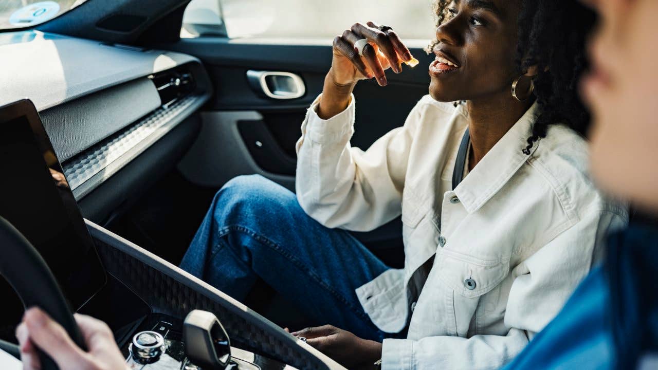 Woman having candy sitting with friend in car