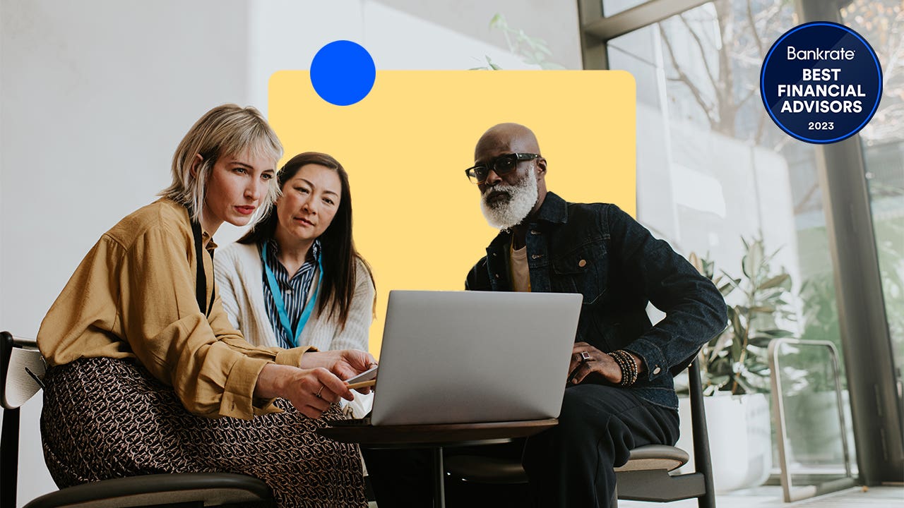 A financial advisor with a pair of clients gathered around their computer