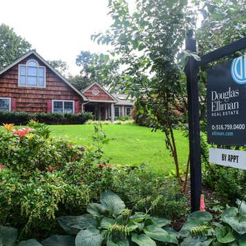 suburban home green lawn for sale sign - why are houses so expensive