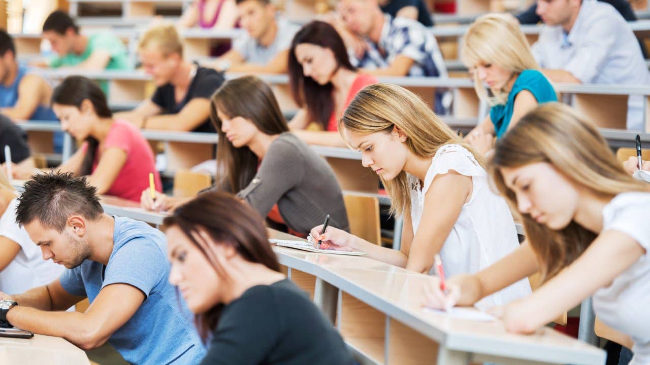 Large group of students writing in notebooks