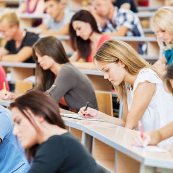 Large group of students writing in notebooks