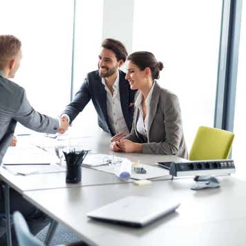 Happy couple meeting their financial advisor, shaking hands