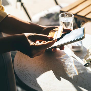Woman using a credit card to pay online bills using mobile application