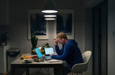 A stressed mature man goes through his home finances at the dining table