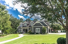 large gray craftsman style home with big lawn