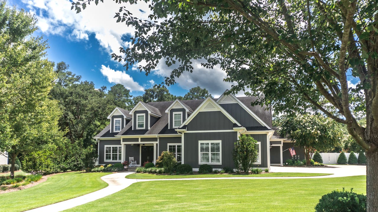 large gray craftsman style home with big lawn