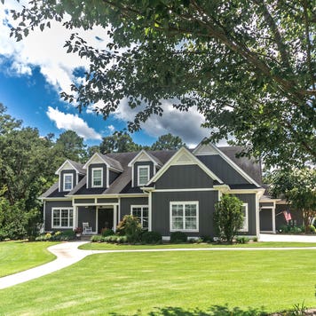 large gray craftsman style home with big lawn