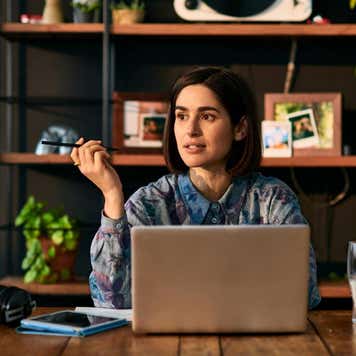 businesswoman using laptop and looking away