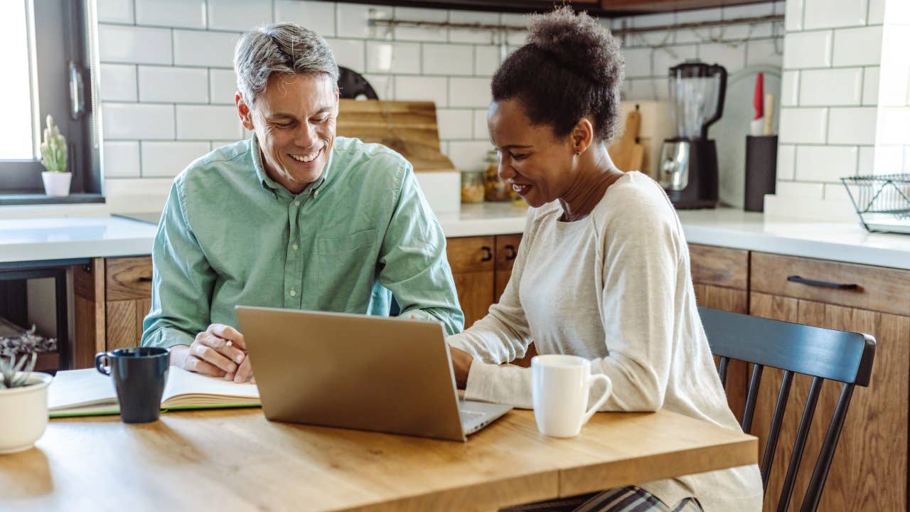 older couple working on financials at kitchen table