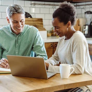 older couple working on financials at kitchen table