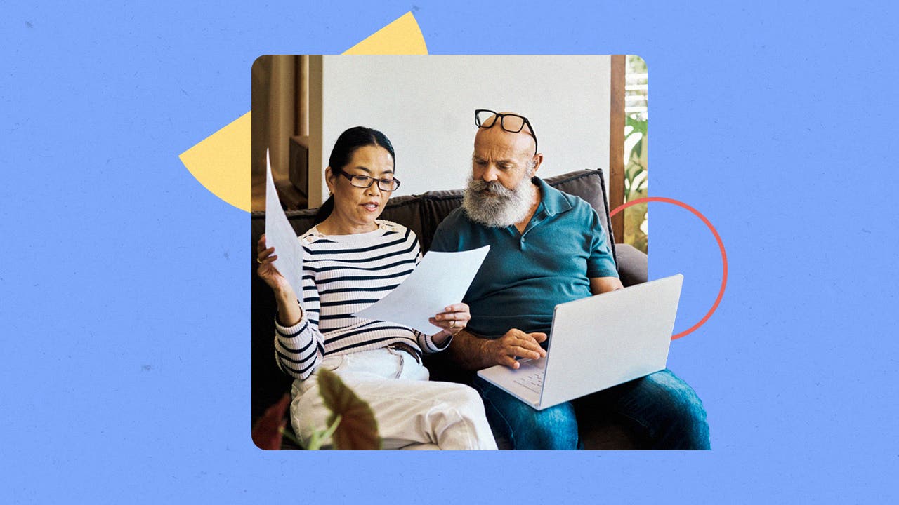 An older couple review financial documents on a couch