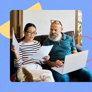 An older couple review financial documents on a couch