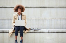 Young businesswoman using laptop while sitting on steps