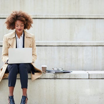 Young businesswoman using laptop while sitting on steps