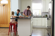 a couple and their child in their kitchen of their new home