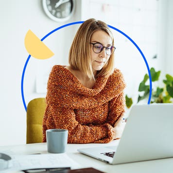 Woman with glasses sitting in front of a laptop.
