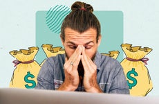A person sitting in front of a laptop computer, their hands on their face expressing frustration.