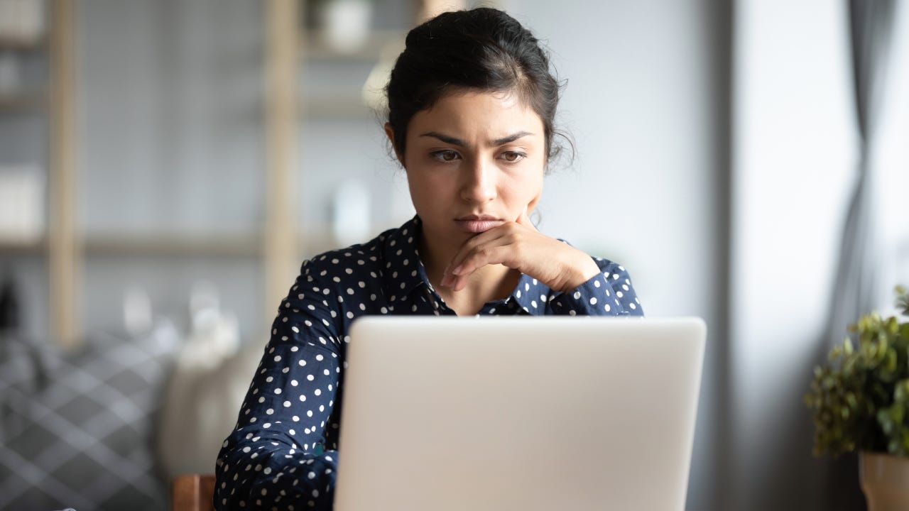 woman read email on laptop feels concerned