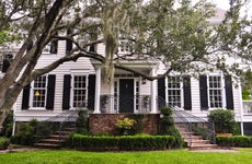 white southern mansion with chokeweed laden tree