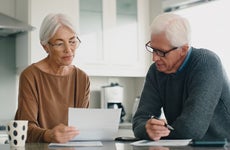 Older couple reading financial documents in their kitchen