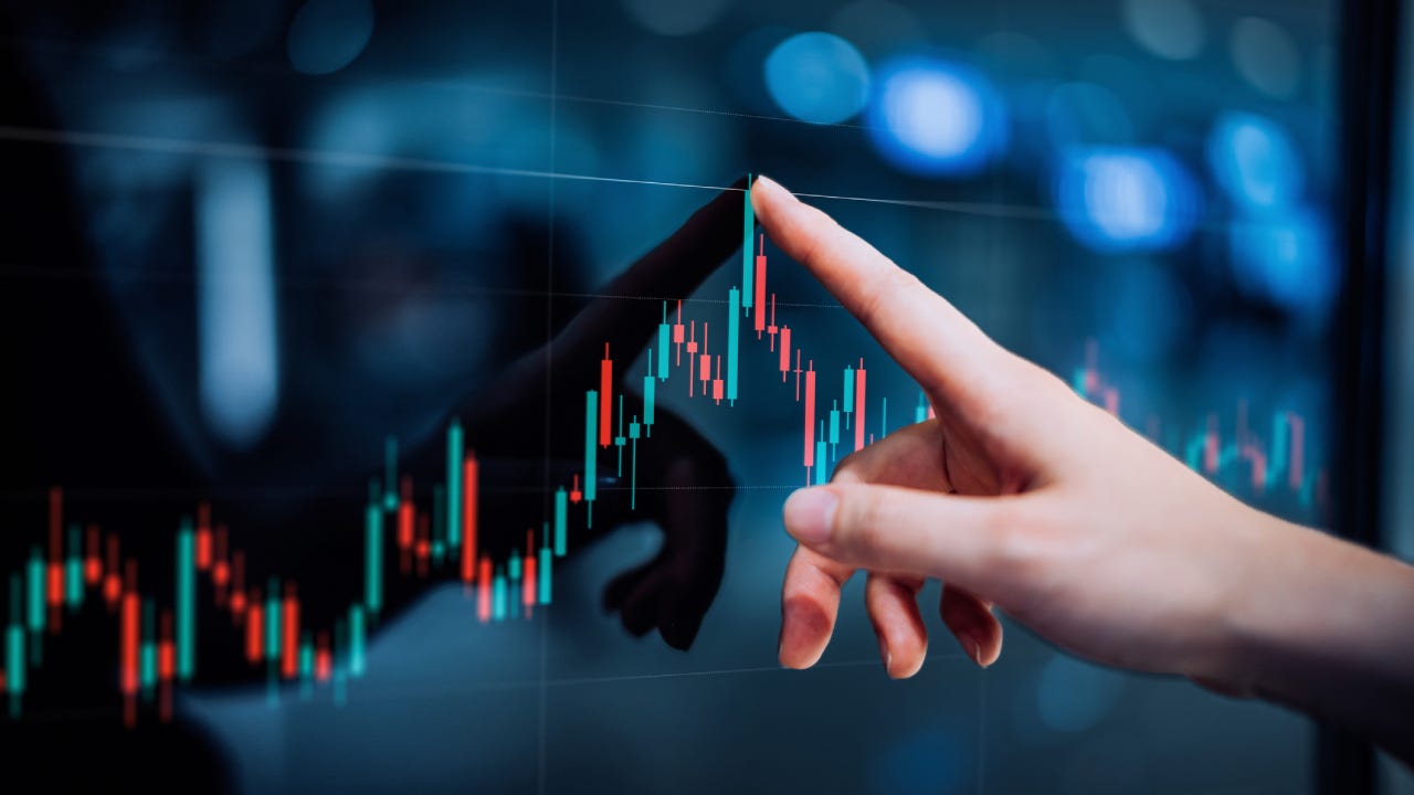 Hand touching a high-tech looking financial candlestick graph