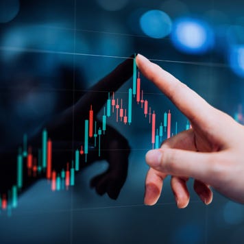 Hand touching a high-tech looking financial candlestick graph
