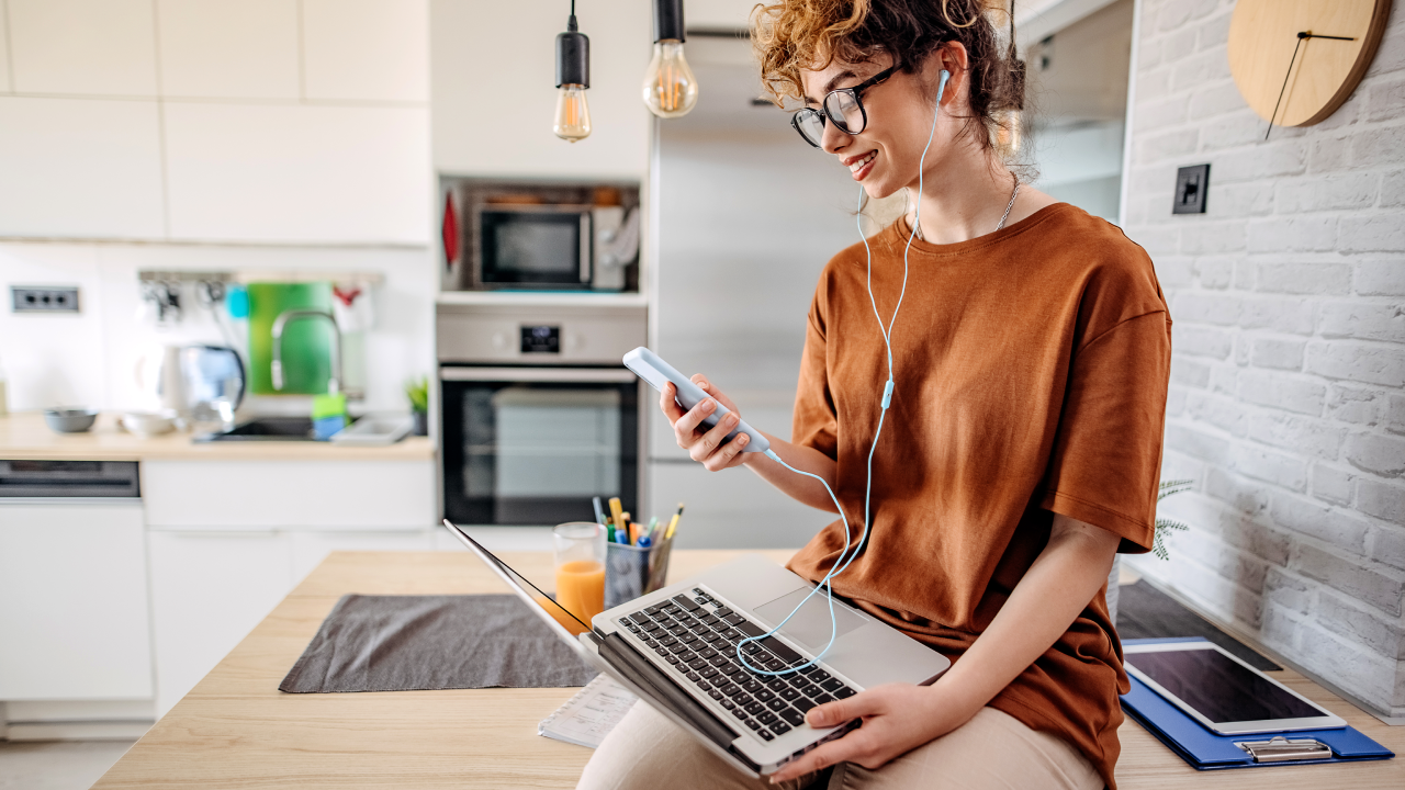 young woman working on laptop in kitchen