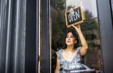 small business owner turning open sign in her store