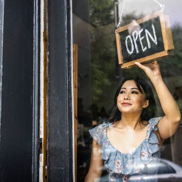 small business owner turning open sign in her store