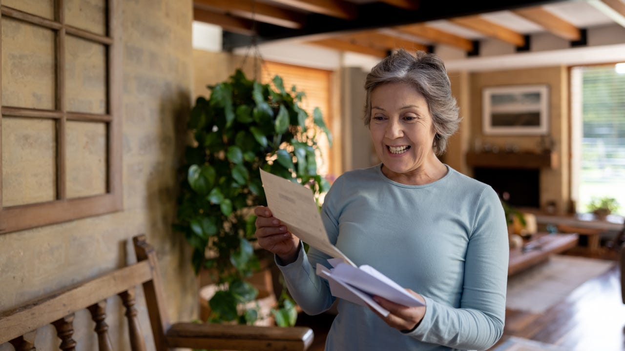 Senior woman looking happy about getting a letter in the mail