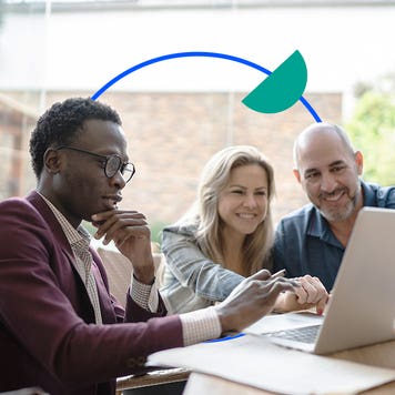 Agent talking with a couple in front of a laptop
