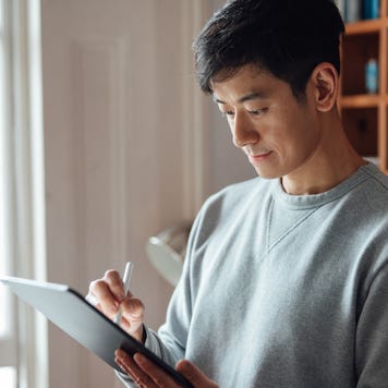 Young man working from home with digital tablet