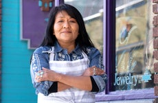 Native American woman stands in front of her small business.