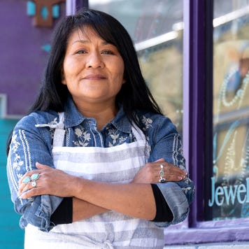Native American woman stands in front of her small business.