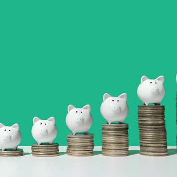 Little piggy banks on ascending stacks of coins