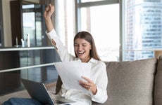 Cheerful young student woman excited with good news