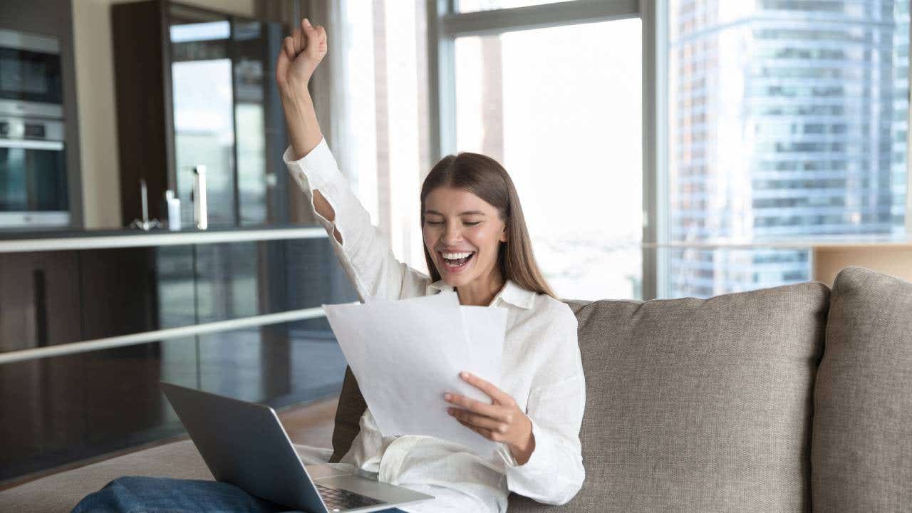 Cheerful young student woman excited with good news