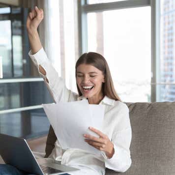 Cheerful young student woman excited with good news