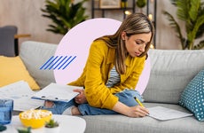 Woman working on paperwork on her couch