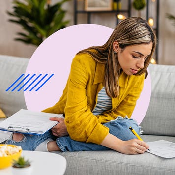 Woman working on paperwork on her couch