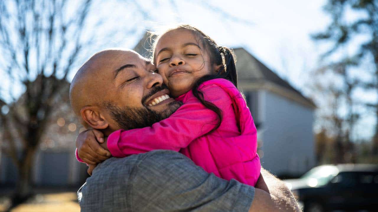 Father holding young daughter outdoors