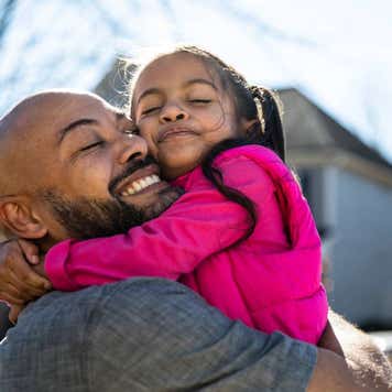 Father holding young daughter outdoors