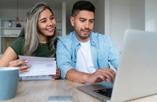 Happy couple at home paying bills online