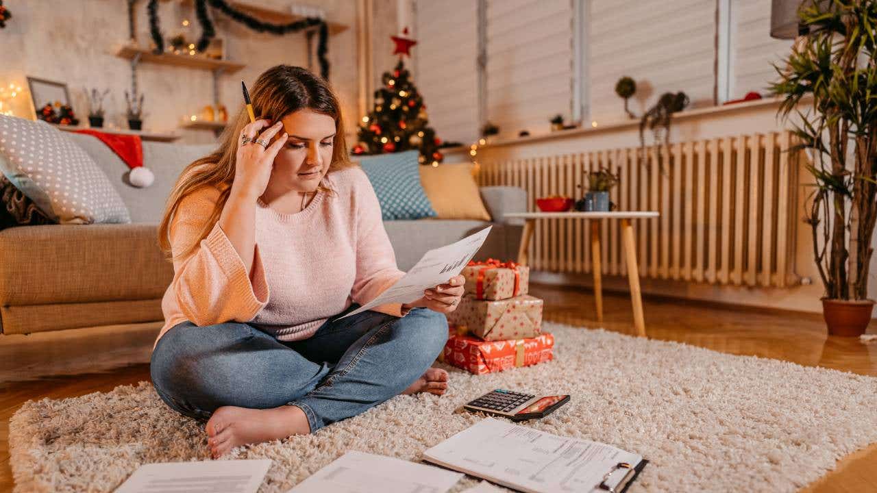 Young worried woman paying bills at Christmas