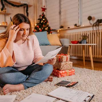 Young worried woman paying bills at Christmas