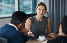 Serious woman talking to business clients in meeting
