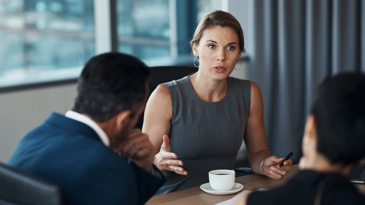Serious woman talking to business clients in meeting