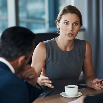 Serious woman talking to business clients in meeting