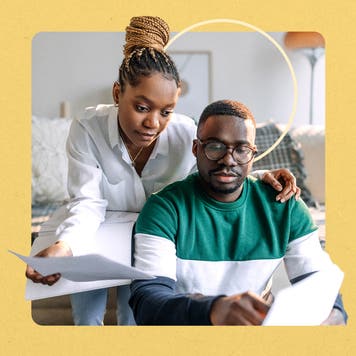 Black man and woman reviewing papers in their living room with a yellow square border and thin yellow circle behind them