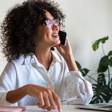 business woman working at home office talking on the phone with client